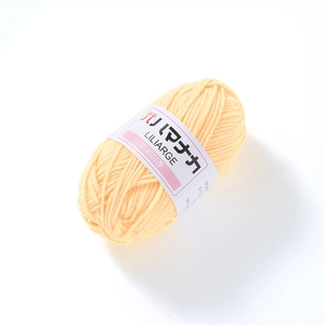 Close-up of soft light yellow 4-ply milk cotton yarn with Hamanaka brand label