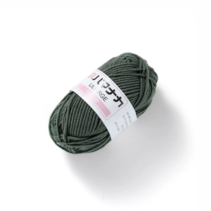 Close-up of olive green 4-ply milk cotton yarn ball with clear knitted texture and label