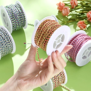 Colorful braided cotton cord on spools for DIY jewelry making and craft weaving