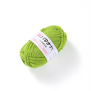 Close-up of 4-ply grass green milk cotton yarn roll for DIY crochet and knitting