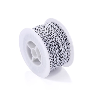 Macro detail of black and white braided cotton cord on a spool for DIY jewelry making