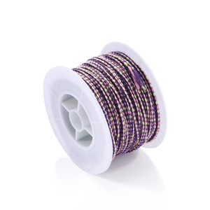 Close-up of multi-colored braided cotton cord on a white spool for DIY bracelet making