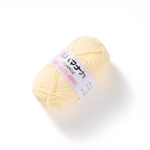 Detailed close-up of cream 4-ply milk cotton yarn ball with Liliarage branding label