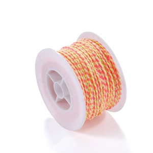 Close-up of pink and yellow braided cotton cord on a white spool for DIY jewelry