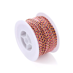 Detail of four-strand braided cotton cord with colorful fibers on a white spool
