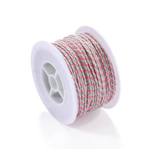 Macro shot of pink, blue, and white braided cotton cord on a white spool for DIY jewelry