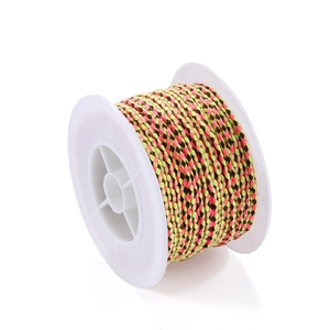 Macro detail of three-color woven cotton rope on white spool for DIY bracelet making