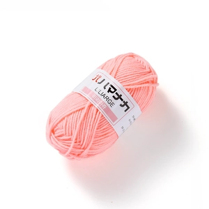 Detail shot of soft pink milk cotton yarn ball with white paper label on white background