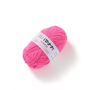 Close-up of rose pink 4-ply milk cotton yarn roll with white paper band wrap