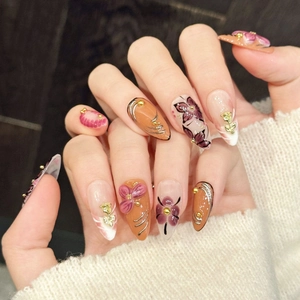 Elegant long almond press-on nails with 3D embossed flowers and gold metallic accents