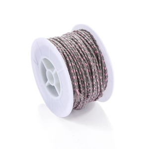 Macro shot of grey and pink braided cotton cord on a white spool for DIY jewelry