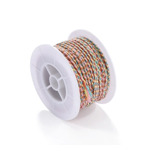 Detailed close-up of rainbow gradient braided cotton cord on a white plastic spool
