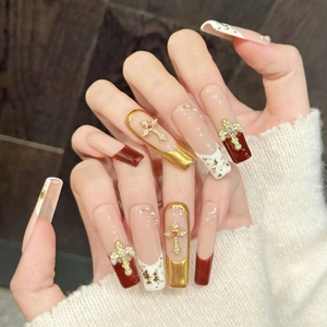 Pink gold and red press-on nails with 3D cross charms, pearls and gold foil accents
