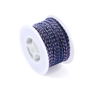Close-up of blue and purple Tibetan style woven cotton cord on a white spool