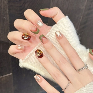 Faux ongles vert olive et ambre avec cristaux, perles et détails élégants