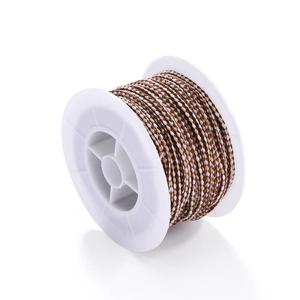 Detail view of tri-color woven cotton cord on a white spool for DIY jewelry making