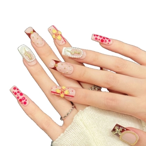 Faux ongles rose poudré faits main avec fleurs 3D et détails croix en perles