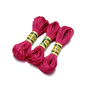 Detailweergave van drie rollen roze 2,5 mm Chinees knoopkoord met spiraaltextuur