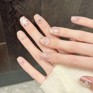 Iridescent snowflake press-on nails with pearls and silver glitter on hand