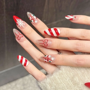 Exquisite Christmas press-on nails featuring 3D bows, snowflakes, and candy cane stripes