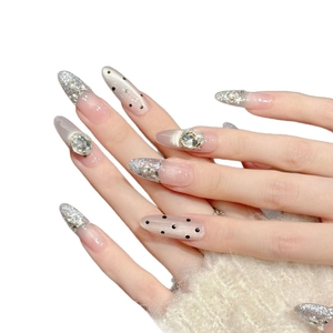 Faux ongles amande faits main avec paillettes argentées, strass et motifs nébuleuse