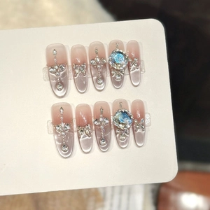 Pink cat eye press-on nails with luxury blue diamonds and metal butterfly decorations