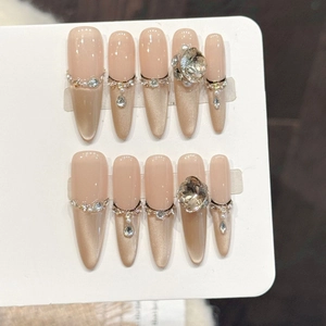 Handmade stiletto press-on nails with nude gradient, cat-eye shimmer and luxury crystals