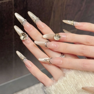 Luxurious nude gradient stiletto nails with champagne cat-eye effect and large rhinestones