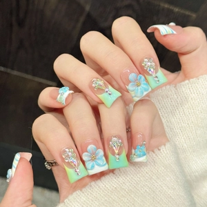 Pink and blue gradient press-on nails with 3D floral accents and sparkling rhinestones