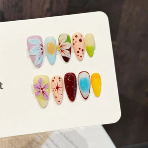 Handcrafted almond fake nails with 3D floral relief and colorful polka dot designs