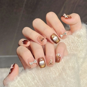 Handmade caramel brown and nude press-on nails with 3D bows and cherry nail art designs