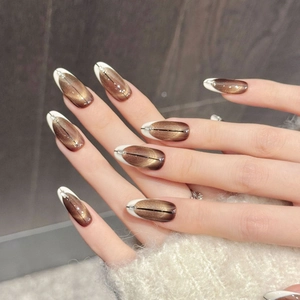 Bruine cat-eye plaknagels met witte French tips en verfijnde kristallen versiering