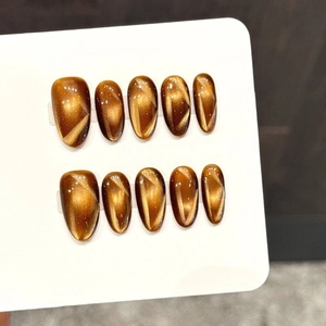 Caramel amber cat-eye press-on nails in oval shape with metallic magnetic luster