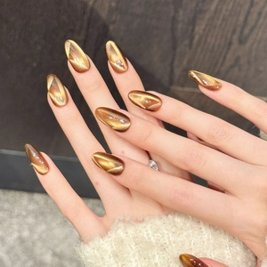 Caramel amber cat-eye press-on nails in elegant long almond shape with golden glow
