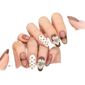 Unghie finte color caramello con fiori 3D intagliati e eleganti motivi a pois