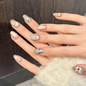 Handmade press-on nails in champagne glitter with pearl flower accents and cat-eye finish