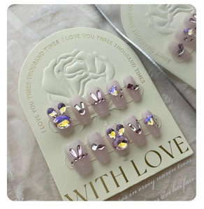 Macro detail of coffin press-on nails with pink 3D rabbit ears and heart rhinestone gems