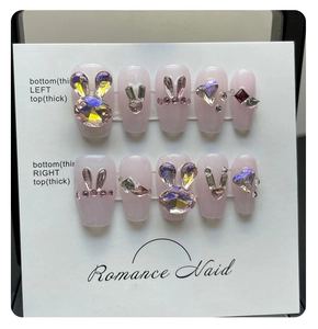 Detail of pink cat eye fake nails with 3D aurora rabbit ears and sparkling crystals