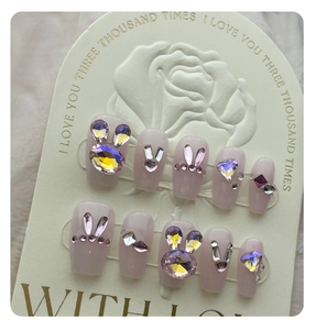Detail of luxury press-on nails with 3D crystal rabbit and heart rhinestones