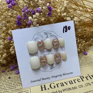 White and shimmering gold glitter press-on toenails with iridescent decorative jewels