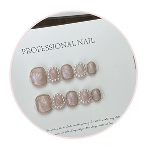 Detail of handmade press-on nails with lily of the valley pearl and gold chain accents