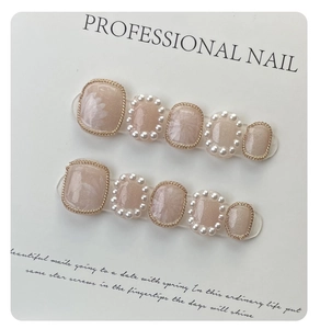 Detailed view of handmade press-on nails with lily of the valley pearl and gold chain