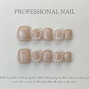 Handmade champagne toe press-on nails with white floral designs and pearl accents
