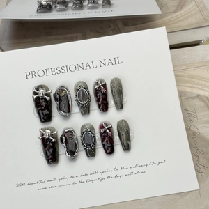 Gothic Halloween press-on nails featuring red marble texture and silver skull charms