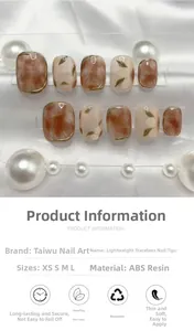 Detail view of brown marble press-on nails with floral patterns and gold accents