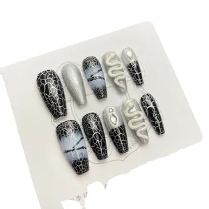 Press-on nails featuring dark black snake skin patterns and 3D silver snake charms