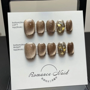 Handmade golden brown cat eye press-on nails with luxury rhinestones on display