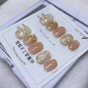 Détail de faux ongles faits main roses avec fleurs 3D et perles dans leur boîte blanche