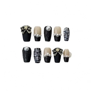 Elegant black and tweed press-on nails with 3D bows, pearls, and golden floral accents