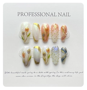 Detail of handmade press-on nails featuring 3D tulips, gold relief, and pearl accents